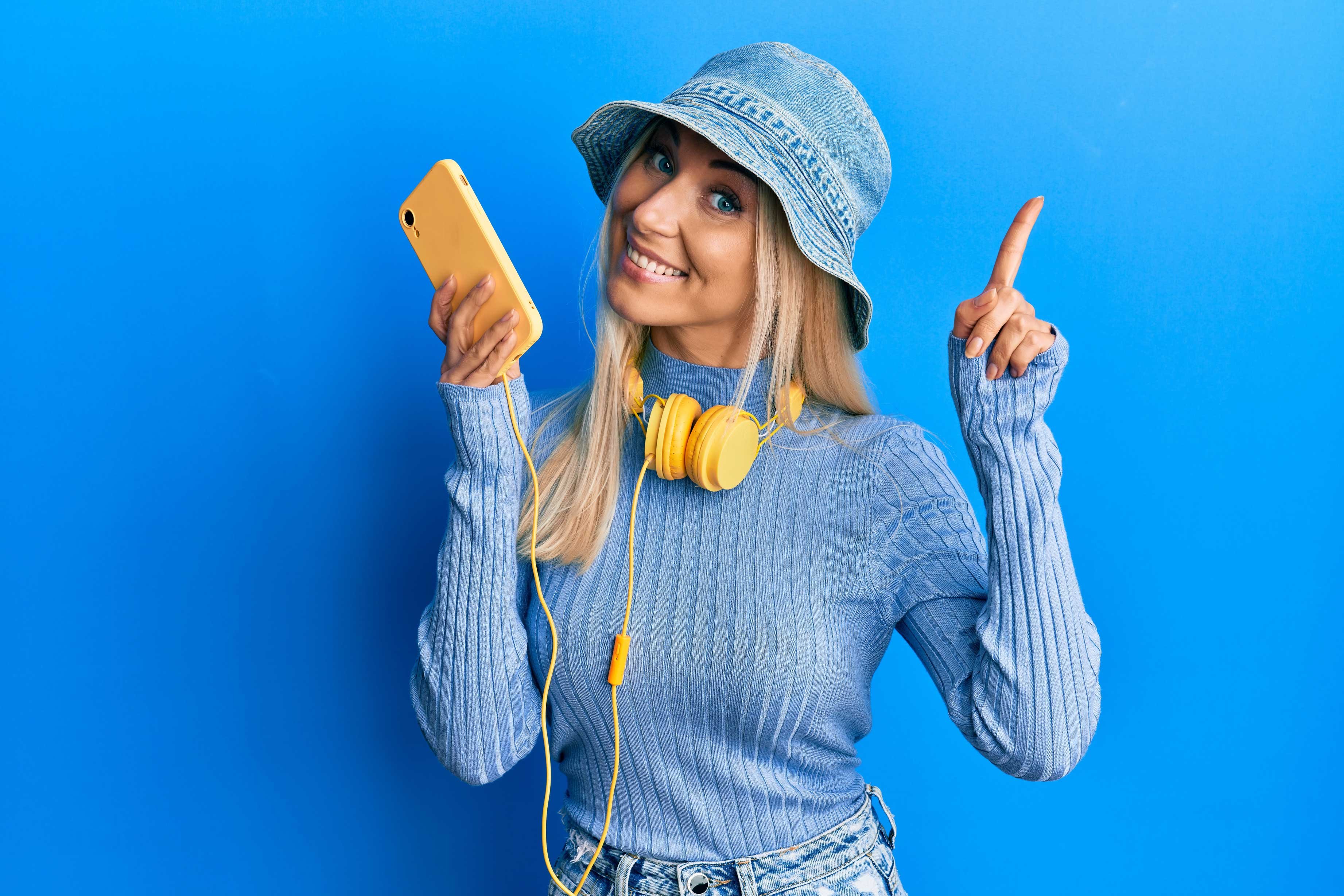 Excited blonde girl holding a yellow phone